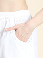 Detailed view of the authentic Chikankari hand embroidery on a white cotton lycra pant. Stylish bottom wear.