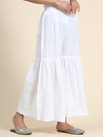 View a comfortable white Garara, with broad elastic waistband and flowing silhouette. Stylish ethnic bottom wear.