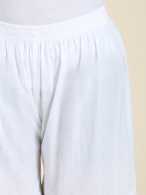 Close-up of exquisite Lucknowi Chikankari hand embroidery on a white Garara bottom wear. Highlights artistry.