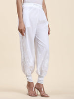 View a stylish white Afghani pant in premium cotton rayon. Features delicate Lucknowi Chikankari bottom wear.