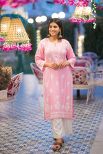 Full front view of a woman in a pink Lucknow Chikan kurta with white embroidery and comfortable palazzo.
