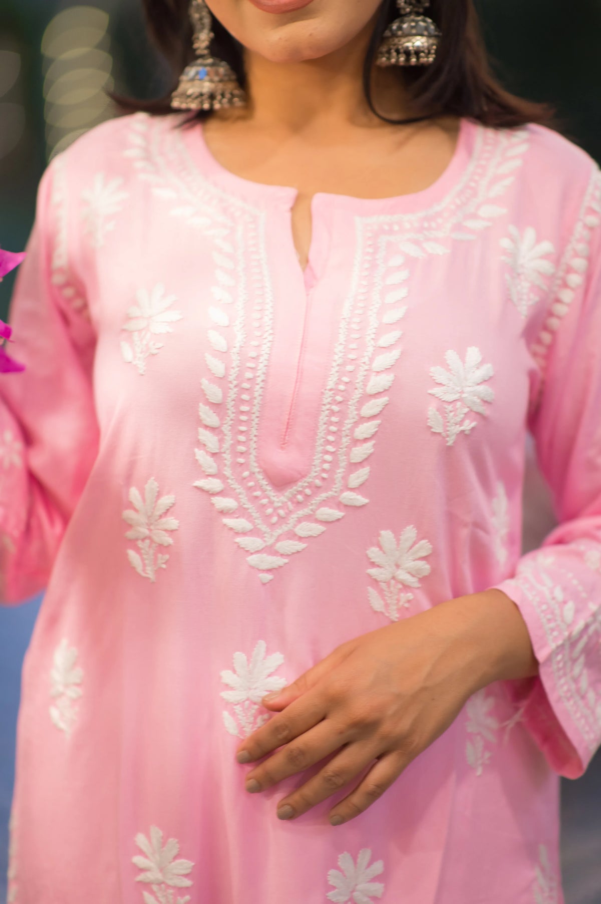 Zoomed front view of a pink Lucknow Chikan kurta showcasing intricate white embroidery, highlighting the delicate handwork.