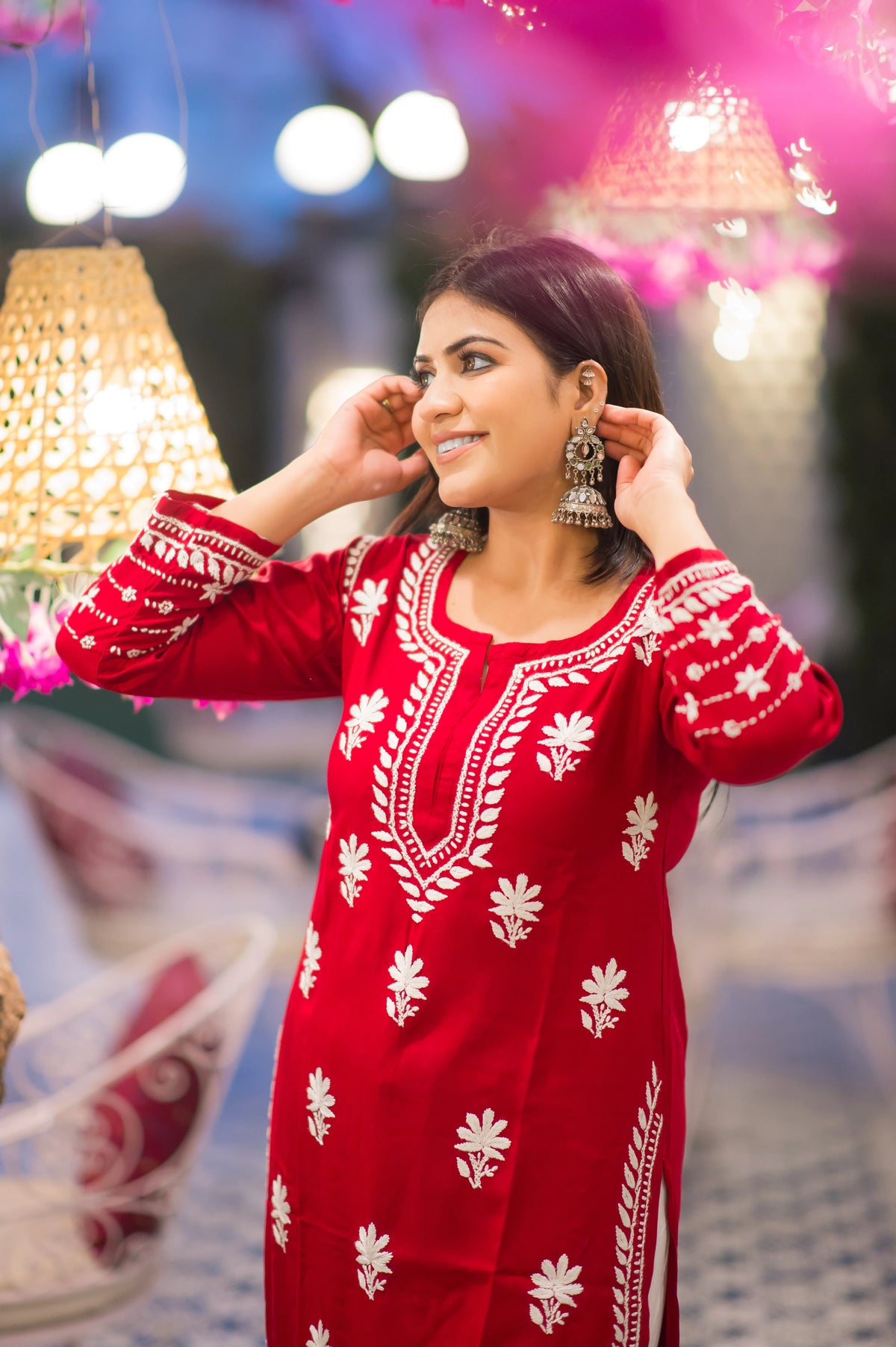 Front view of a woman in a flowing red Indian kurta with white-on-red design.
