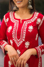 Close-up front view of a red kurta with textured white designer embroidery on the neckline.