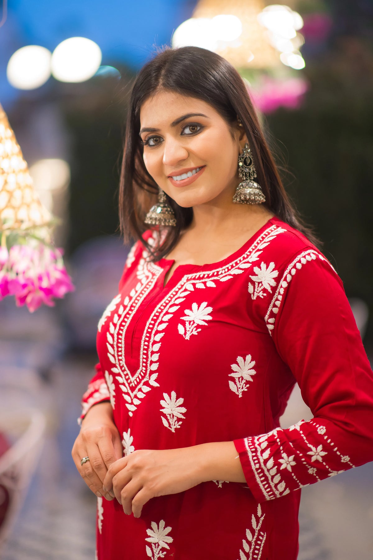 Close-up of delicate white chikankari embroidery on a vibrant red kurta.