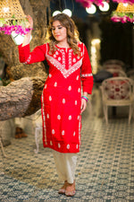 Front view of a vibrant red Lucknowi Chikankari Kurta. This pure cotton Kurti for women showcases elegant white floral embroidery and a comfortable straight fit.