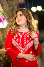 Close-up view of the neckline of a red Lucknowi kurta for women. The intricate white Chikankari on this pure cotton kurta, part of our summer collection