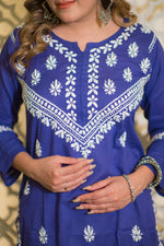 Back view of a woman in a trending blue riwayat kurta with a single white embroidered motif.