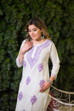 Side angle view of a woman in a mulmul white kurta with a single purple embroidered motif.