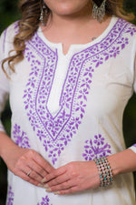 Close-up front view of the purple detailed embroidery on a white chikankari work kurta's neckline.