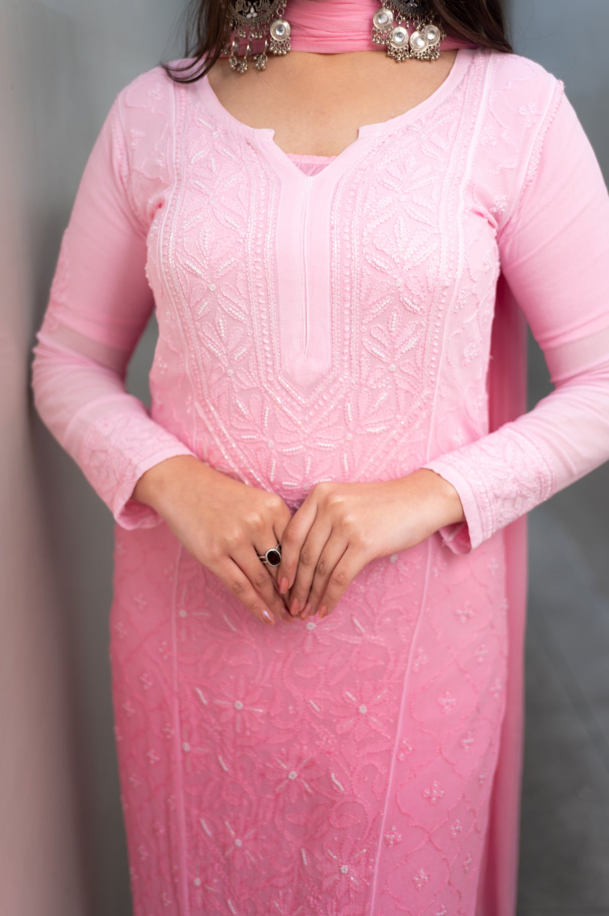 Close-up of intricate Chikankari and dazzling Mukaish on a Pink viscose georgette fabric.