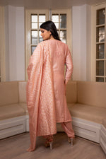 A woman elegantly showcases a back view of a Pink chanderi kurta set, its chanderi fabric adding grace.