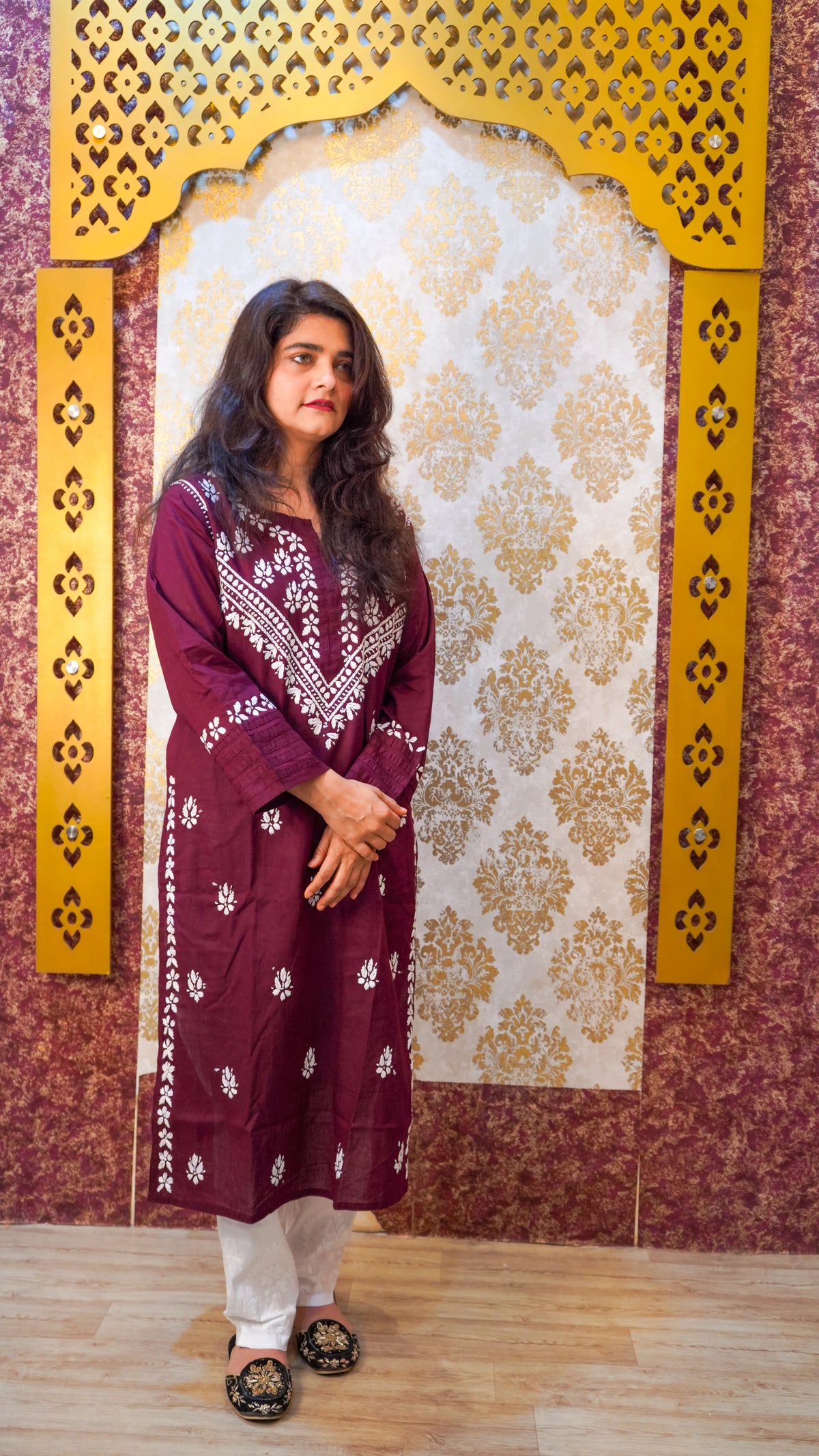 Angled view of a wine Chikankari kurti, showcasing its soft texture and elegant ethnic design.