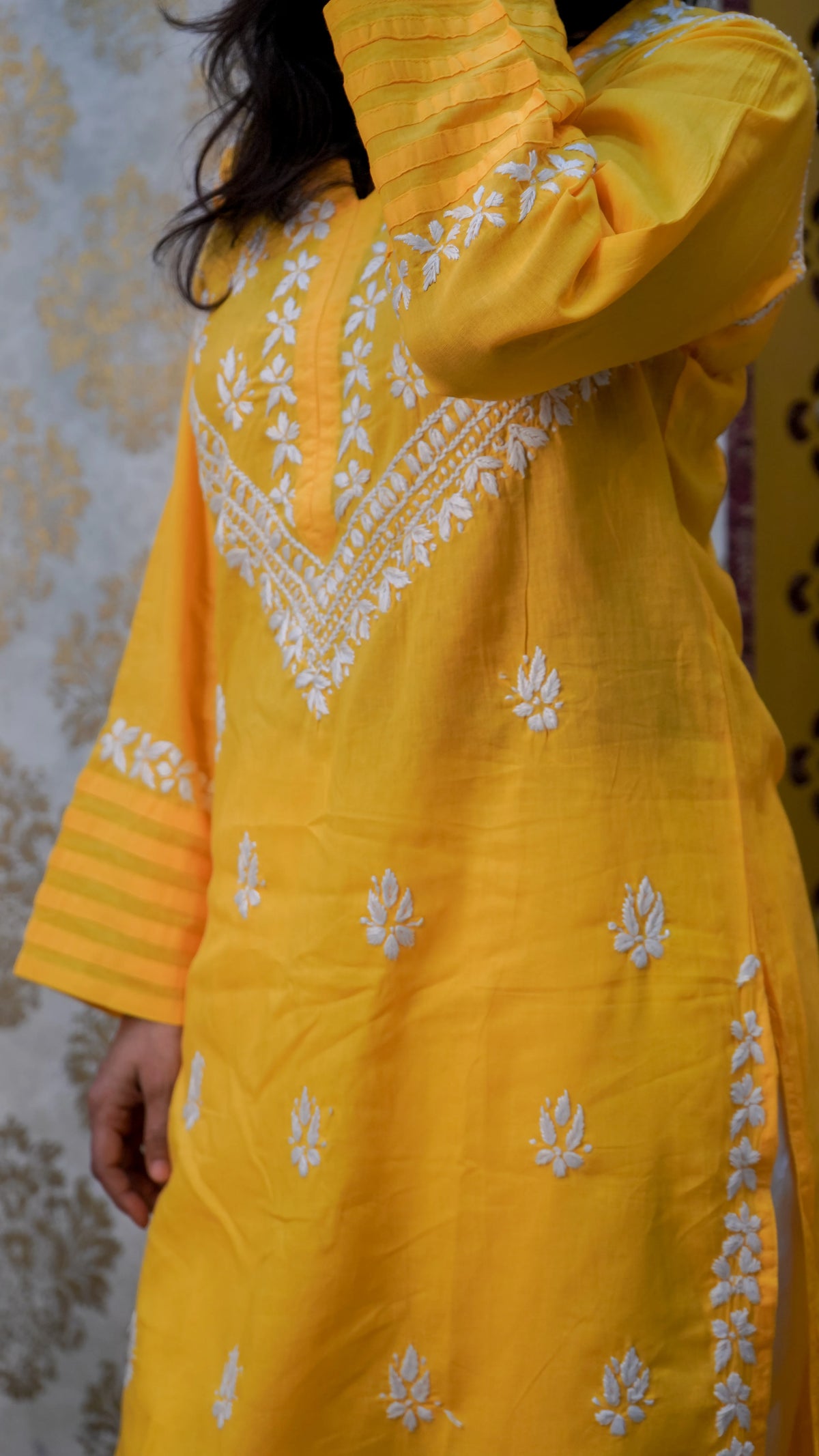 Side view of yellow cotton kurti with white hand embroidery and pleated sleeves, showing detailed Chikankari design clearly.
