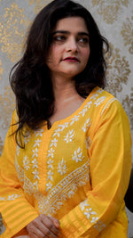 Close-up of a yellow cotton kurti with white hand embroidery and a simple sleeve design, perfect for daily or festive wear.