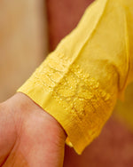 Close-up of white Viscose Georgette Kurti with intricate Chikankari and shimmering mirror work.