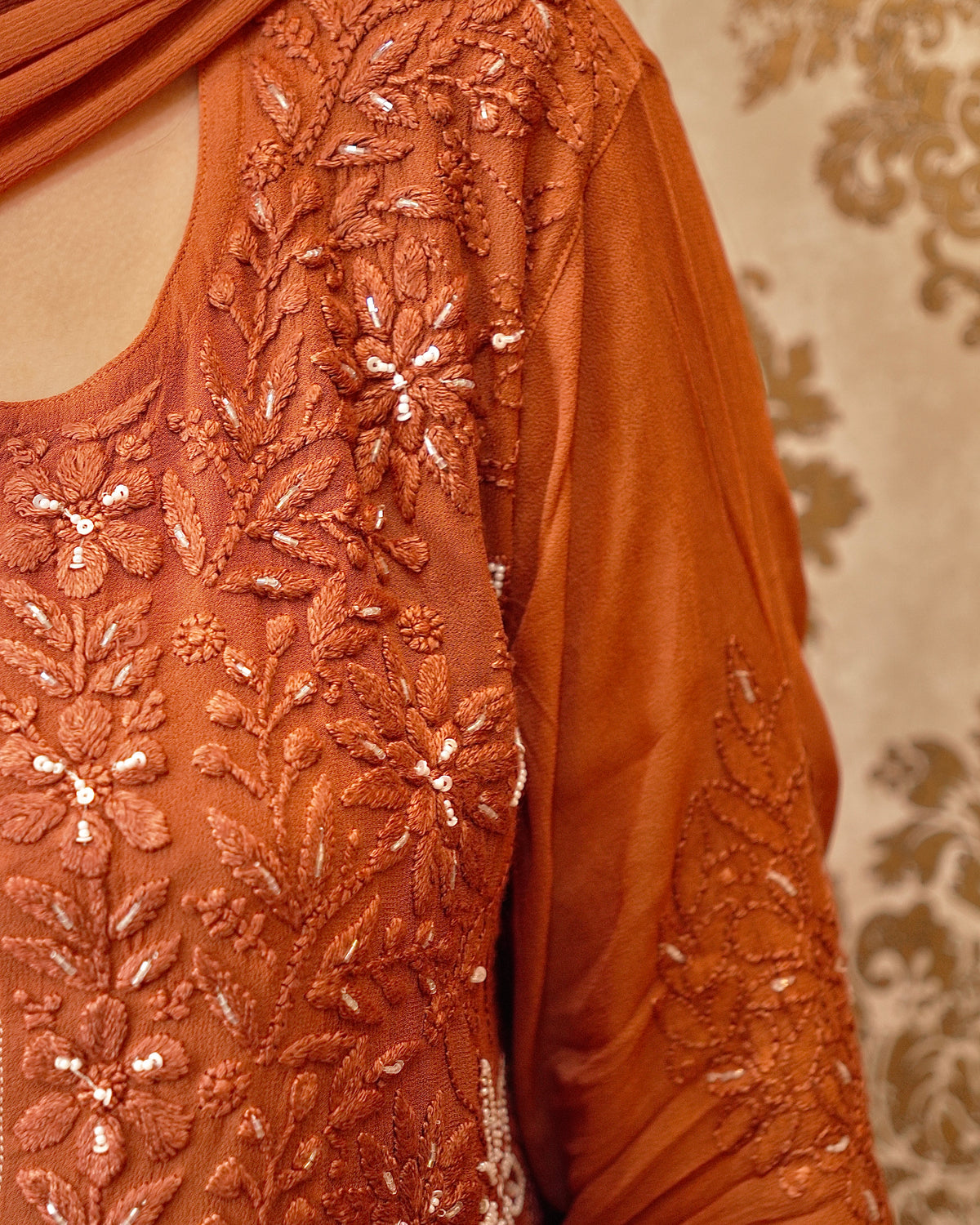 Close-up of rich Zardozi and Chikankari embroidery on an orange Viscose Georgette Kurti.
