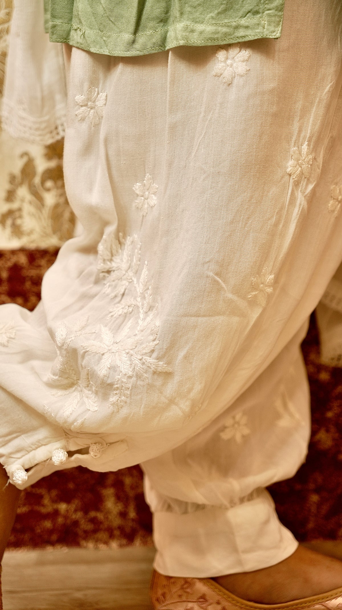 View a light and flowy white Afghani pant, ideal for summer comfort. Features authentic Chikankari bottom wear.