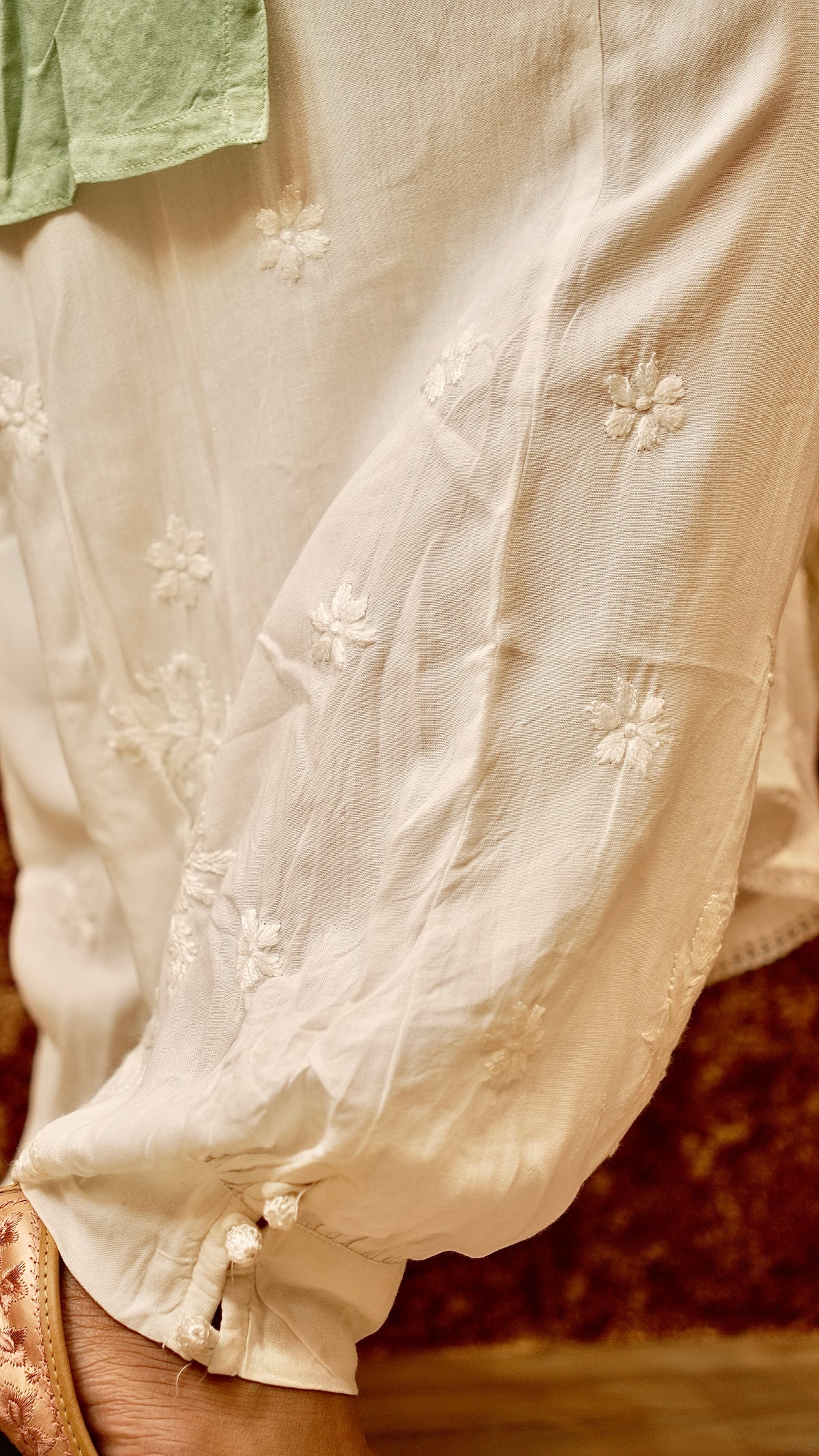 Close-up of the unique gathering and hand embroidery on a white Afghani pant. Stylish ethnic bottom wear.