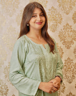 Side front view of pista green Chikankari short kurta with intricate embroidery on the neckline & sleeves.
