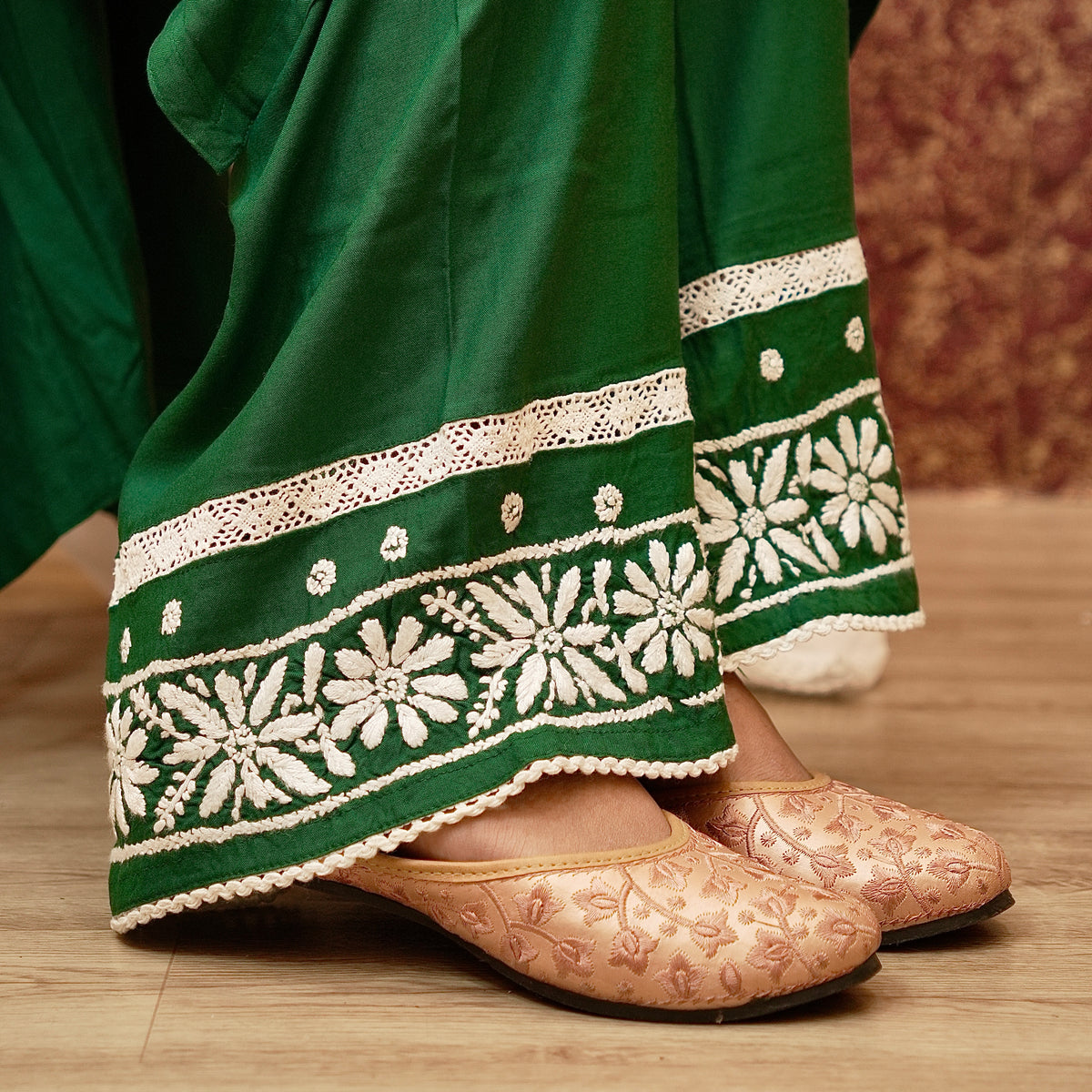 Close-up view of trouser design with white embroidery and lace. Bottle Green Viscose Rayon fabric, chic and comfortable.