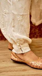 View a flowy white Afghani pant in breathable cotton rayon. Features authentic Chikankari bottom wear.