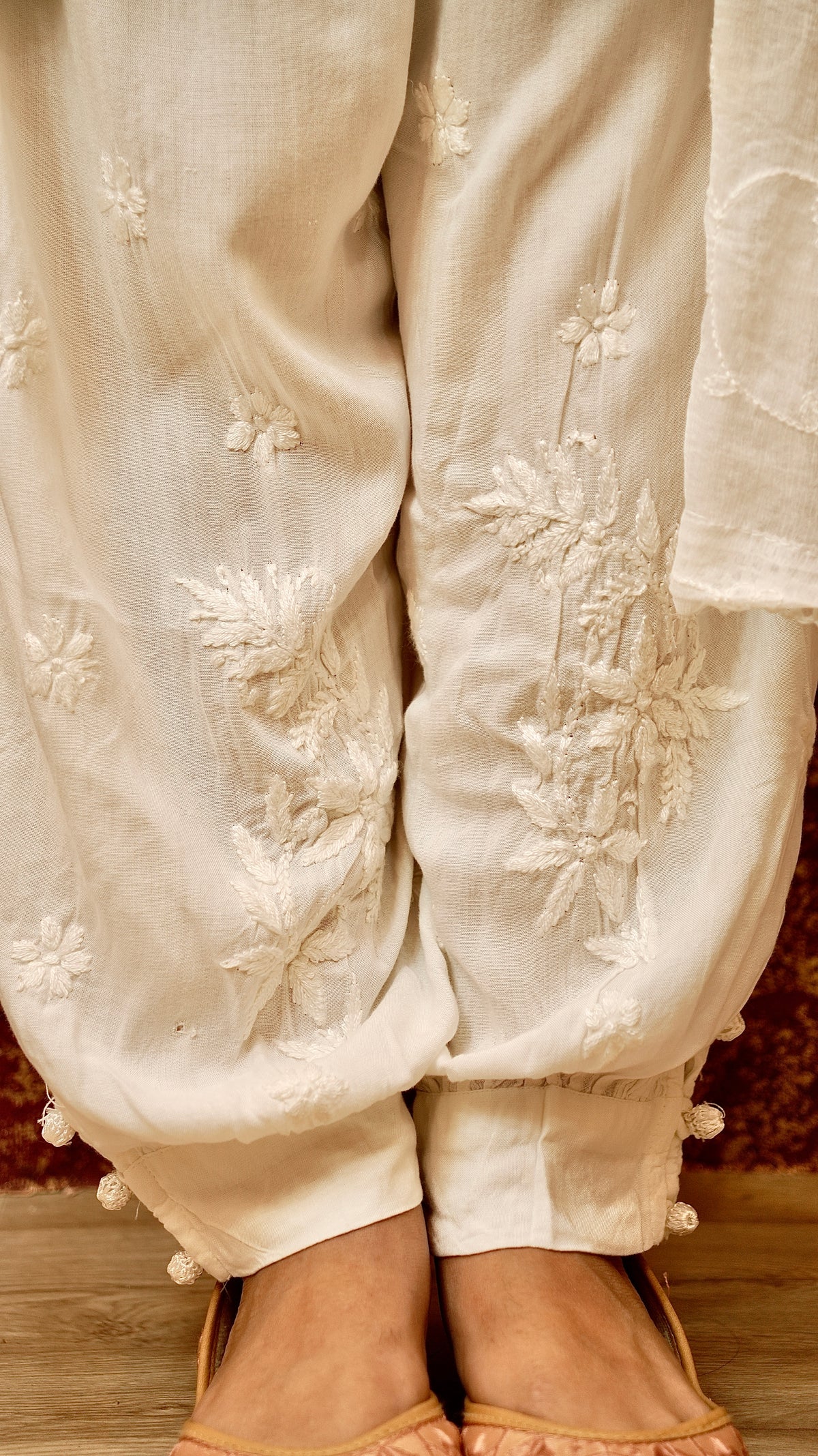 View a designer white Afghani pant with distinctive silhouette. Perfect for trendy ethnic bottom wear.