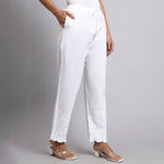 White pants worn by a person on a gray background