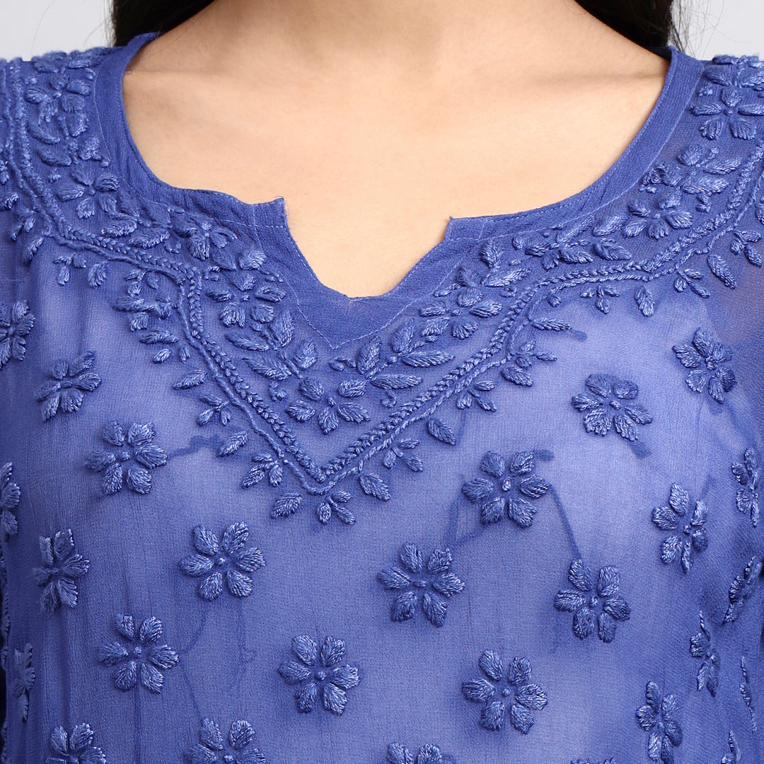 Close-up of a blue embroidered garment with floral patterns.