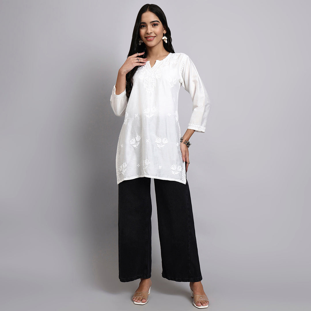 Woman wearing a white kurta with black pants on a gray background