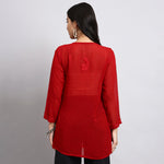 Back view of Red short kurta worn by a person on a plain background
