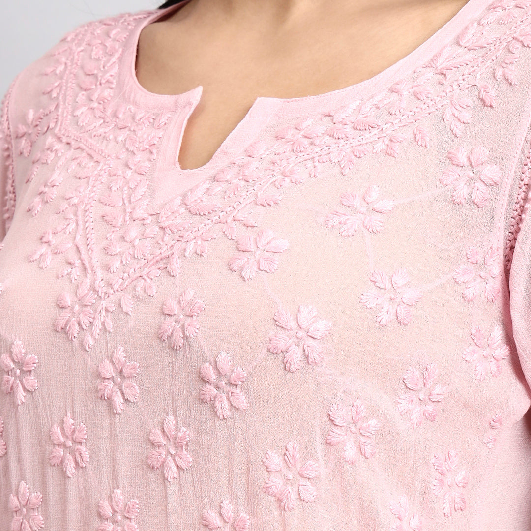 Close-up of a pink embroidered kurta with floral patterns.