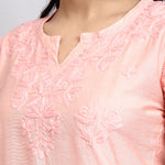 Close-up of a pink embroidered garment with a blurred background