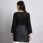 Back view of wearing a black sheer short kurta with a plain background