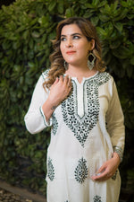 An angled view shows a woman in a white kurti that features intricate green threadwork embroidery.