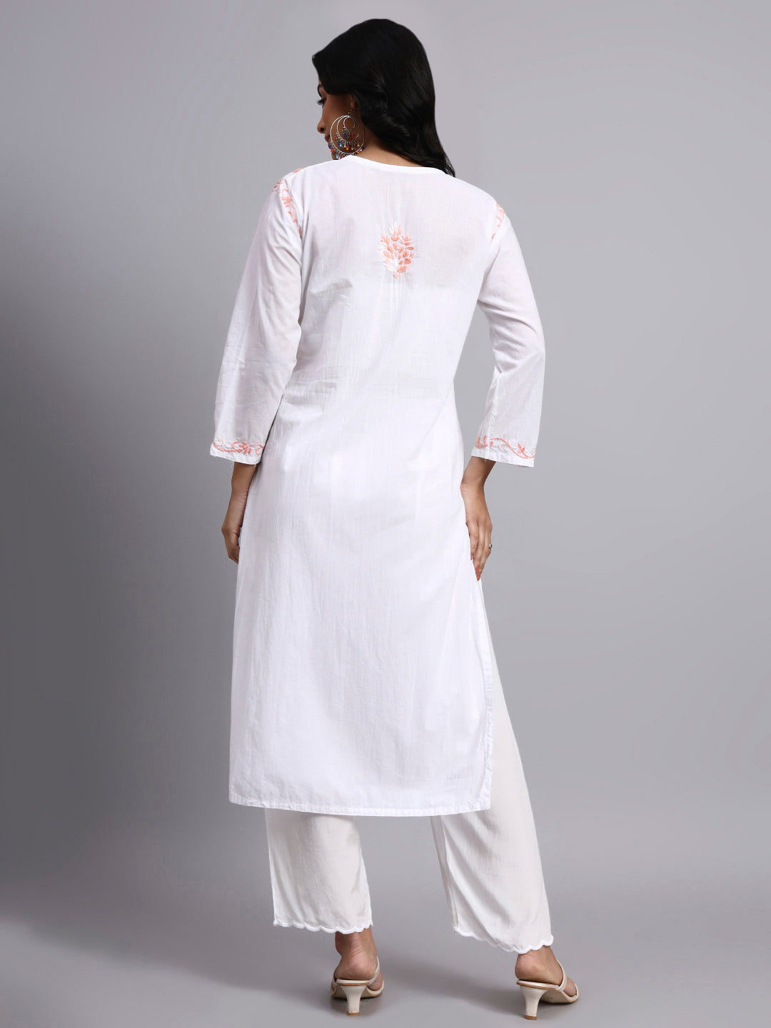 Back view of Woman wearing a white kurta with intricate embroidery on a gray background