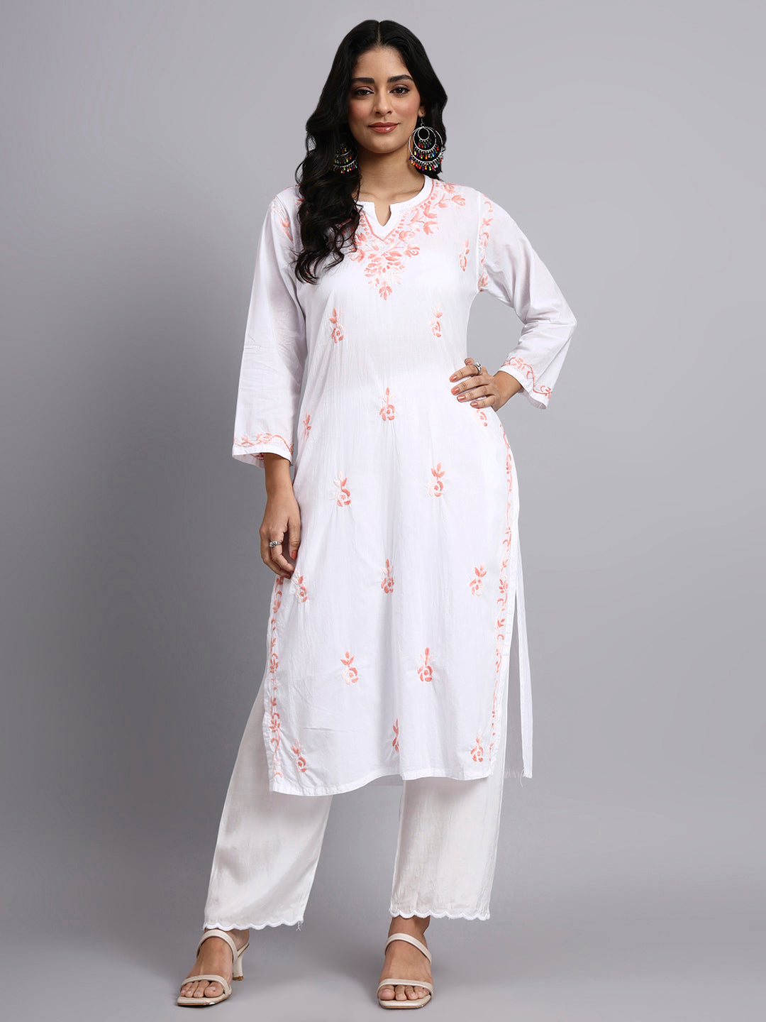 Full view of Woman wearing a white chikankari kurti with floral patterns on a gray background