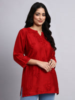 Side view of Woman wearing a red kurta with floral patterns on a gray background