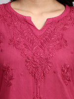 Close-up of a pink embroidered garment with intricate designs.