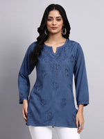 Front view of Woman wearing a blue embroidered chikankari kurti against a gray background