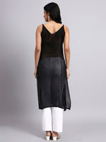Back view of Woman wearing a black sleeveless kurti with white pants on a gray background