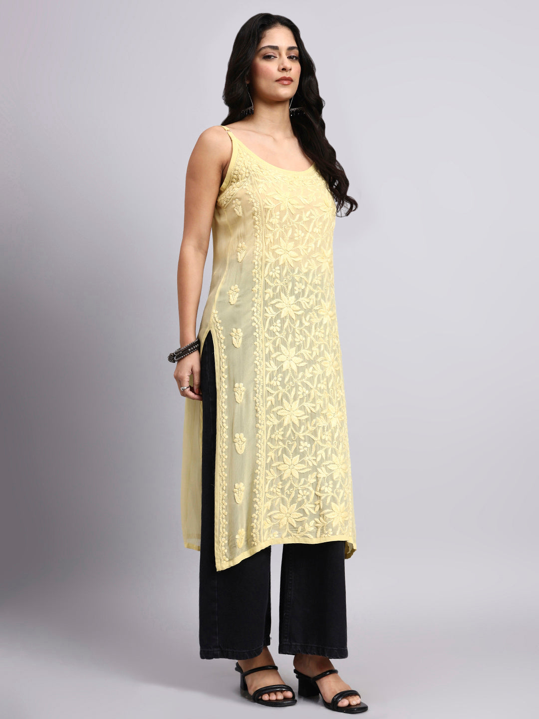 Woman wearing a yellow and black traditional outfit on a gray background