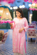 Side view of a woman in a pink Lucknow Chikan kurta with white embroidery, 