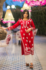 Red chikankari kurti displayed flat elegant festive outfit for womens ethnic wardrobe.