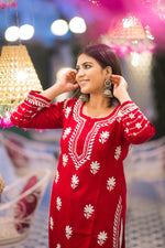 Front view of a woman in a flowing red Indian kurta with white-on-red design.
