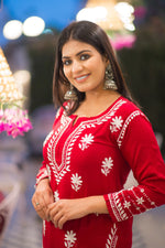 Close-up of delicate white chikankari embroidery on a vibrant red kurta.
