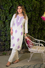 Front view of a woman in a white chikankari fabric kurta with purple floral embroidery.