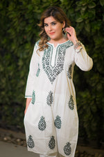 Angled view of a woman wearing a white chikankari kurta with detailed black threadwork.