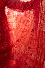 Close-up Red organza net fabric with delicate embroidery. View beautiful organza dupatta material, vibrant ethnic wear.