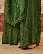 View the elegant drape of a dark green Viscose Georgette Kurta Set with 3D Chikankari.